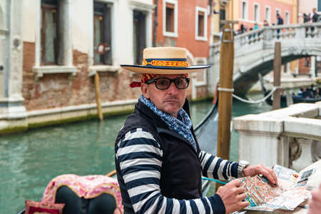 Venice, Italy - October, 2019: Gondolier on a gondola on canal street in Venice, Italy.のeditorial素材