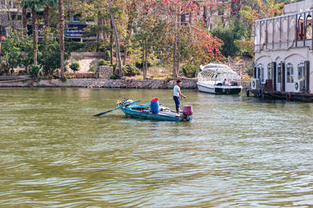 CAIRO, EGYPT - February 2021: Fisherman on a boat. Daily life on Nile river in Cairo, Egypt.のeditorial素材