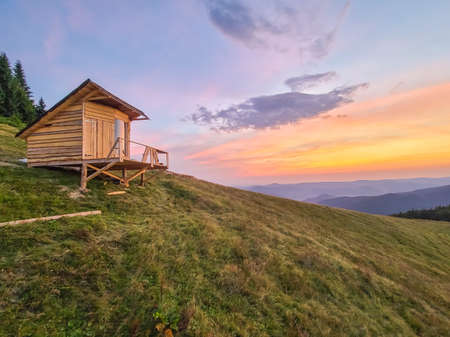 Wooden hut cabin on the Yavirnyk meadow in the Carpathians at sunrise.の写真素材
