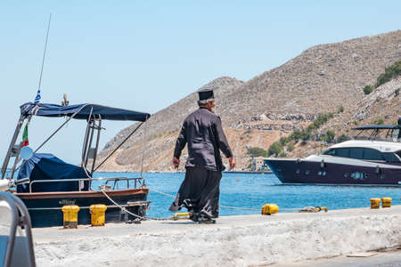 Symi, Greece - June 2021: Greek priest on Symi Island near Rhodes, Greece.のeditorial素材