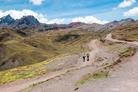 Local Peruvian man with a horse in the Peruvian Andes close to Vinicunca Rainbow Mountain.の写真素材