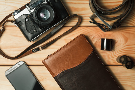 Camera, notebook and mobile phone on a wooden background. Still life. top viewの写真素材