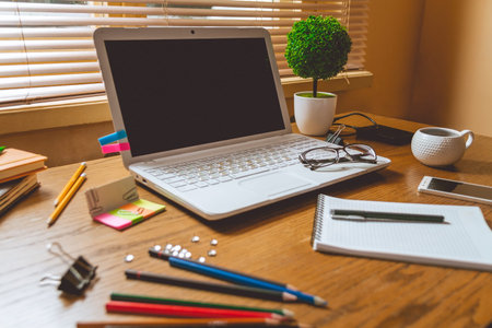 Top view of comfortable working place in office with wooden table and computer standing on it