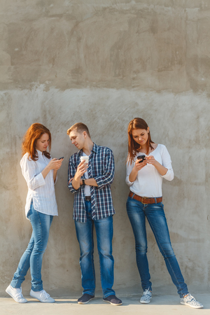 The company of young people, in which each busy with his business. Dependence on gadgets. Interenet dependence conceptの写真素材