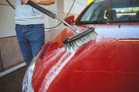 Contactless car wash self-service. Young man washing his carの写真素材