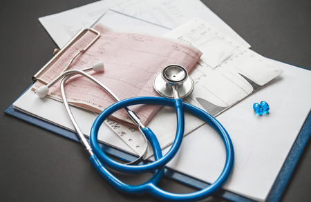 A patients medical card close-up, a stethoscope and pills on the doctors deskの写真素材