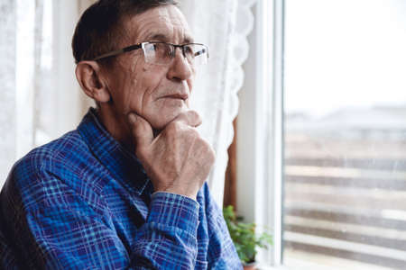 Elderly man solves sudoku or a crossword puzzle to slow the progression of Alzheimer's diseaseの写真素材