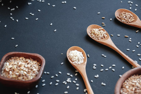 Cooking background Set of different types of rice and cereals in the wooden bowls and a bamboo spoonの写真素材