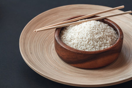 White rice in a wooden bowl with wooden chopsticksの写真素材