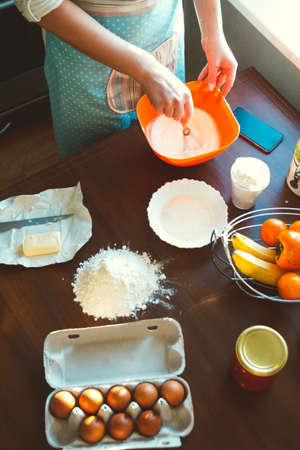 Young Woman cooking in the Kitchen, prepares the dough for bakingの写真素材