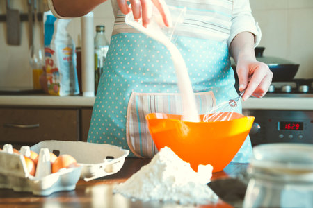 Young Woman cooking in the Kitchen, prepares the dough for baking