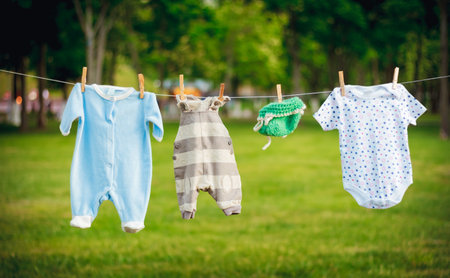 Children's clothes on a rope in the park, expectations of birth conceptの写真素材