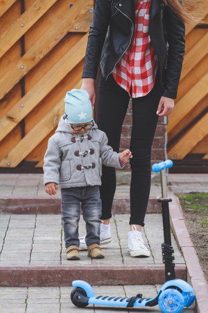 A little boy with vision problems and his mother with glasses in their everyday life are playing outdoorsの写真素材