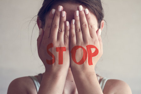 A young woman covers her face with her hands. Domestic Violence Conceptの写真素材