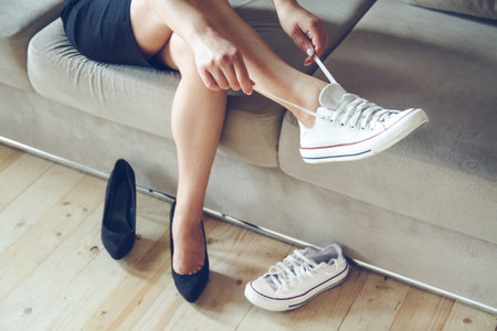 Young beautiful woman makes the choice between comfortable and uncomfortable shoes. Beautiful or comfortable shoes conceptの写真素材