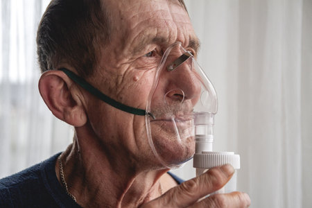 An elderly senior with an oxygen mask in quarantineの写真素材