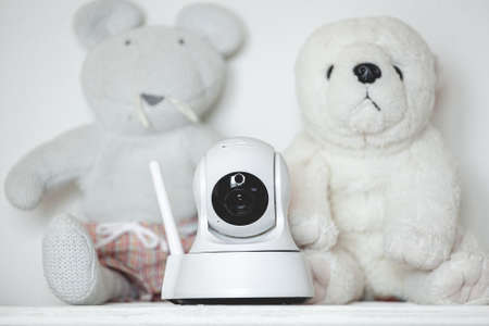 IP camera on the shelf with toys, serving as a baby monitorの写真素材