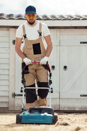 Scarifying lawn with a scarifier, Man gardener scarifies the lawn and removal of old grass