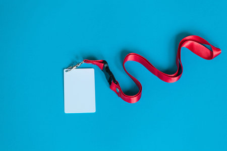 White plastic badge and red Lanyard with blank space mock up isolated on blue background