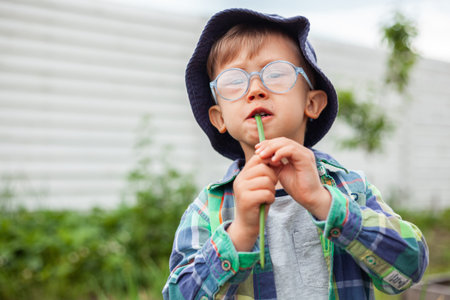 Child gardening and eat green onionsin in vegetable garden in the backyard