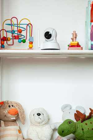 IP camera on the shelf with toys, serving as baby monitorの写真素材