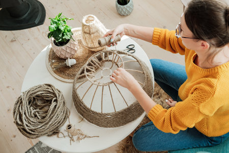 Woman makes handmade diy lamp from jute rope
