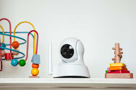 IP camera on the shelf with toys, serving as a baby monitorの写真素材