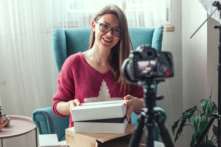 Close-up camera screen, woman blogger makes video of unpacking gadgets at homeの写真素材