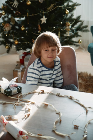 The child is interested in his gift on Christmas morning