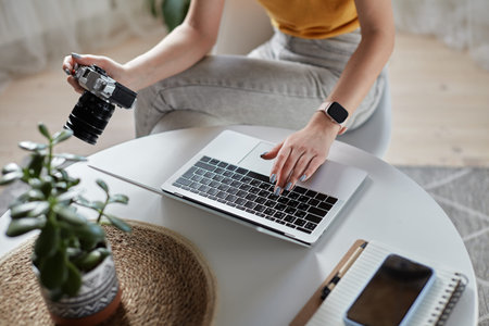 Young woman designer or freelancer working at home using computer sitting at table at homeの写真素材