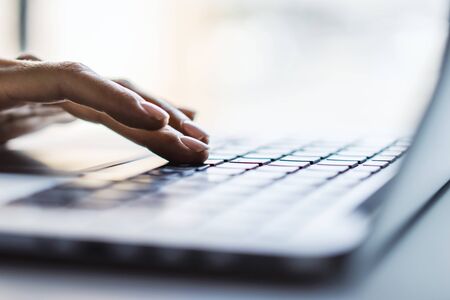 Female hand presses a button on laptop, closeupの写真素材