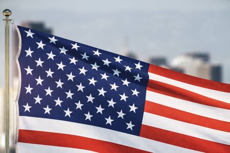 The American flag waving on a blurry city background . Close Upの写真素材