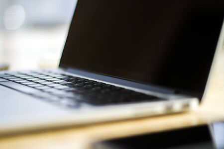 Close up of modern laptop on wooden table in sunny interior. Business and technology conceptの写真素材