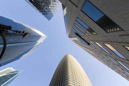 Perspective view of modern office buildings in financial district at sunset, real estate and success concept, USAの写真素材