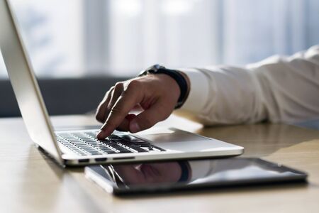 Male finger presses a button on a computer keyboard, business and technology concept. Close upの写真素材