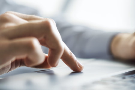 Man hands typing on laptop keyboard in sunny office, business and technology concept. Close up