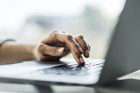Female finger presses a button on a laptop keyboard, business and technology concept. Close up
