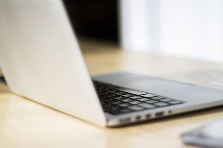 Close up of modern laptop on wooden table in sunny interior. Business and technology conceptの写真素材