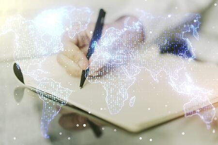 Multi exposure of abstract graphic world map and man hand writing in notepad on background, connection and communication conceptの写真素材