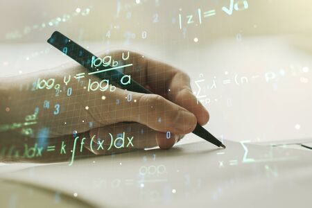Creative scientific formula hologram with man hand writing in notepad on background, research concept. Multiexposureの写真素材