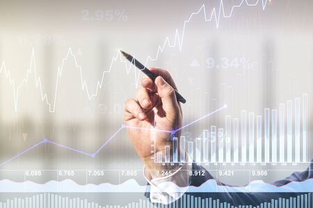 Multi exposure of analyst hand with pen working with virtual abstract financial diagram on blurred office background, banking and accounting conceptの写真素材