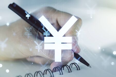 Double exposure of creative Japanese Yen symbol hologram and man hand writing in notebook on background. Banking and investing conceptの写真素材