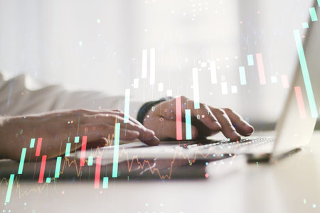 Double exposure of abstract creative financial diagram with hand typing on computer keyboard on...