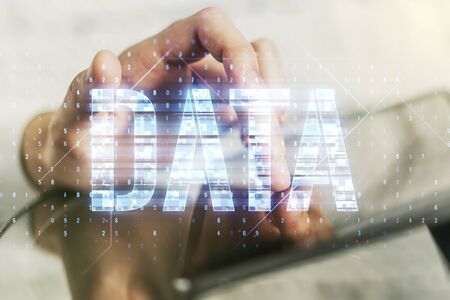 Creative Data word hologram and finger clicks on a digital tablet on background, big data and blockchain concept. Multiexposureの写真素材