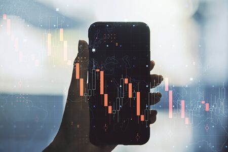 Creative concept of crisis chart illustration and hand with phone on background. Global crisis and bankruptcy concept. Multiexposureの写真素材