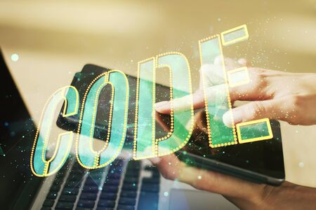 Creative Code word sign and finger clicks on a digital tablet on background, international software development concept. Multiexposureの写真素材