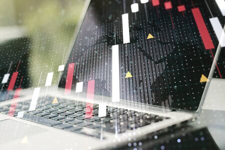 Abstract creative financial graph with world map on modern laptop background, forex and investment concept. Multiexposureの写真素材