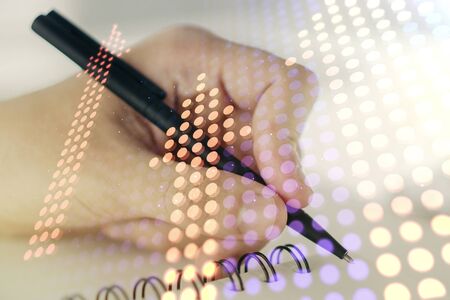 Double exposure of creative abstract upward arrows hologram and man hand writing in notebook on background. Ambition and challenge conceptの写真素材