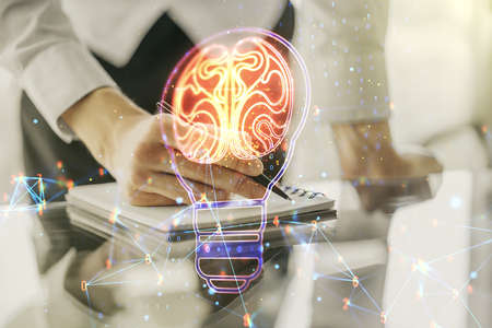 Double exposure of creative light bulb hologram with human brain and with man hand writing in notebook on background, idea and brainstorming conceptの写真素材