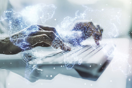 Abstract creative world map and hands typing on laptop on background, international trading concept....